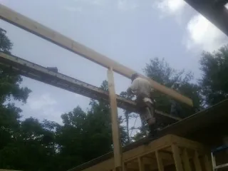 Carpenter setting a ridge beam over a new addition frame — Ice Dam Removal by Roofing Brothers in Blue Rapids