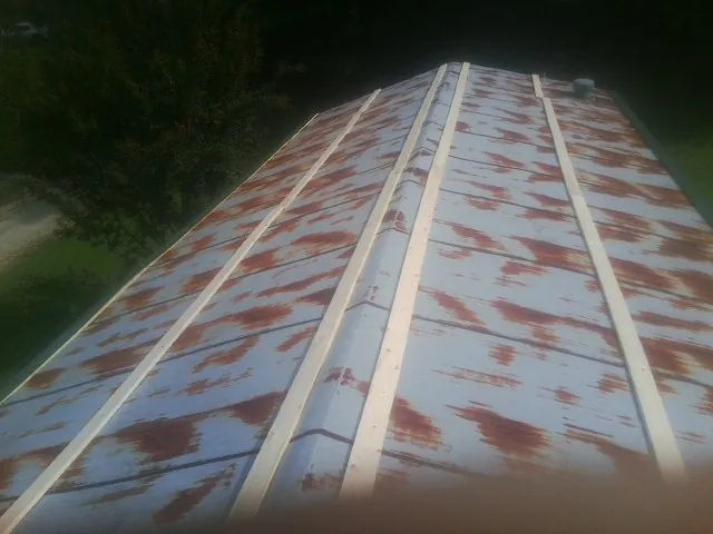Rusted metal roof panels with new wood purlins before replacement — Storm Damage Roof Repair in Blue Rapids by Roofing Brothers