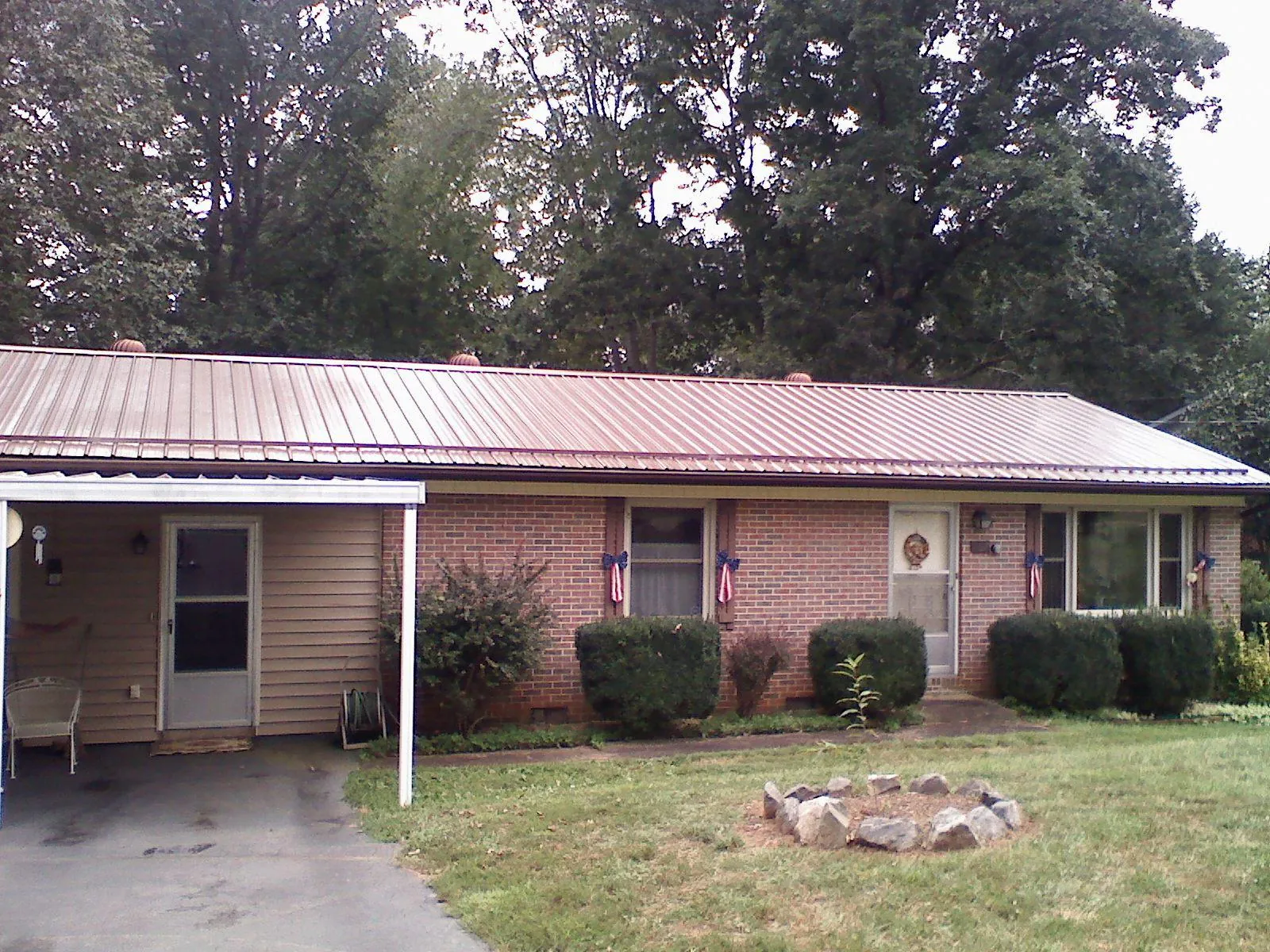 Bronze metal roof and carport on a brick ranch home — Roof Repair work by our crew in Blue Rapids