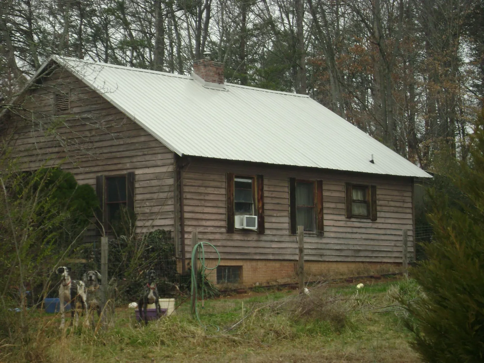 White metal roof on an old wood sided farmhouse, from a Metal Roof Installation job in Blue Rapids